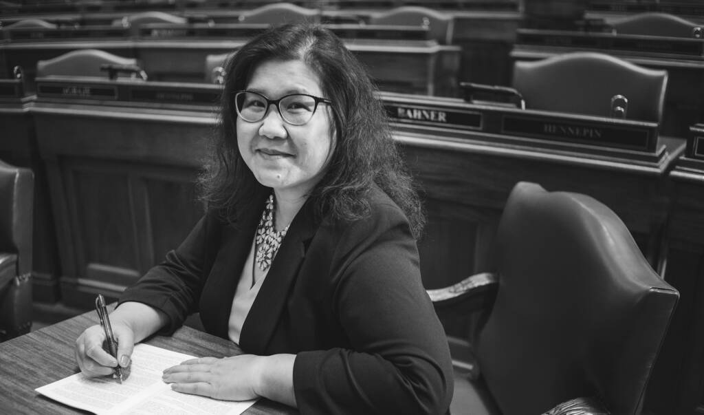 Photo of Kaohly Her at her desk in the Minnesota House chamber.