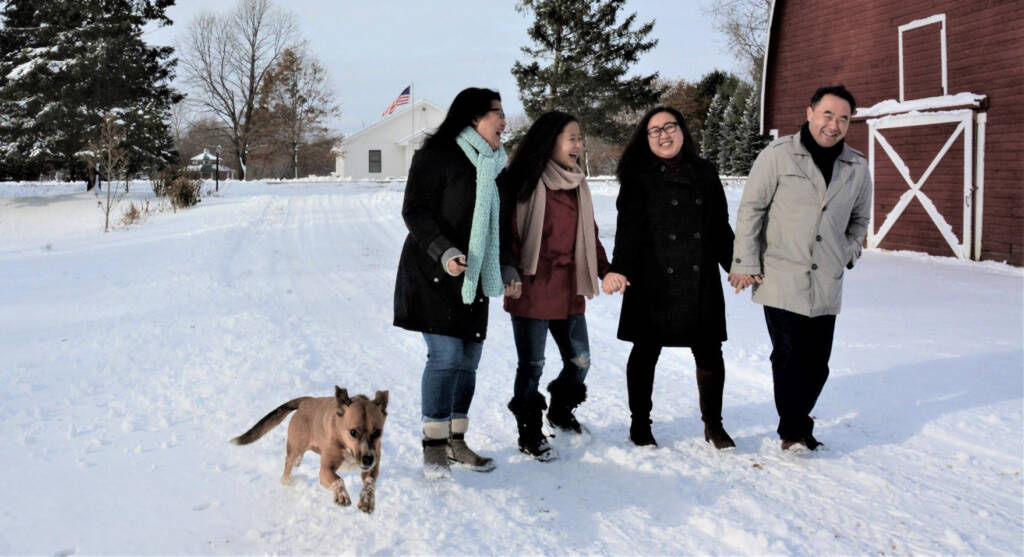 Photo of Kaohly Her walking with her family and late dog at their farm in winter time.