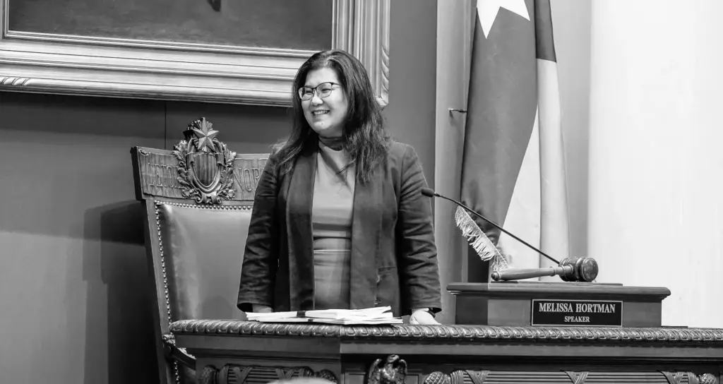 Photo of Kaohly Her in the Minnesota House Chamber at the desk of late Speaker Melissa Hortman